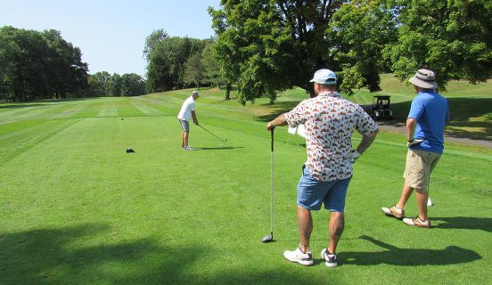 Three people playing golf on a golf course at the Golf for Kids events