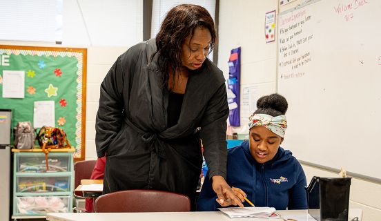 Adult woman helping girl with homework