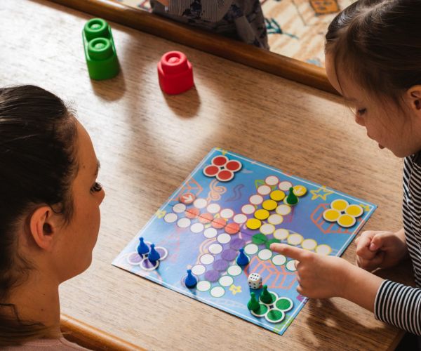 A child and a woman playing a board game together