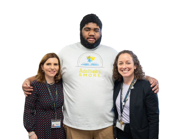 Two women smiling next to a tall young man