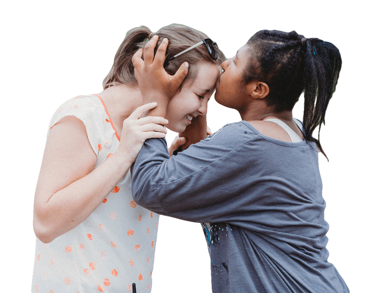 A young woman kissing the forehead of another young woman