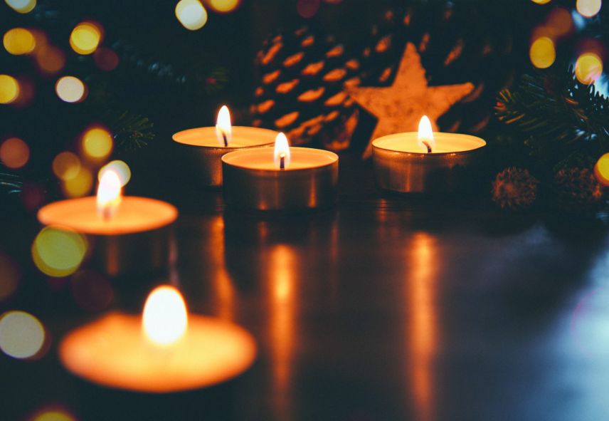 Closeup of lit candles in a dark setting