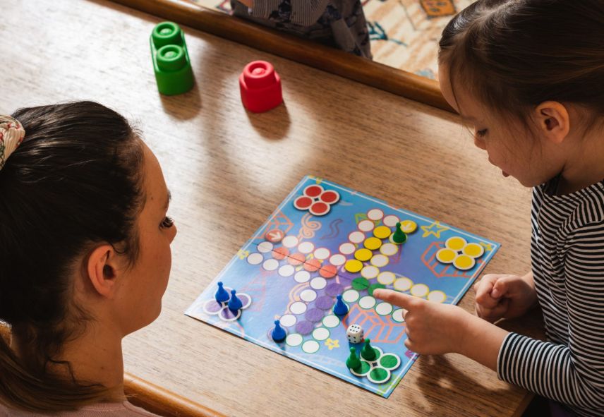 A child and a woman playing a board game together